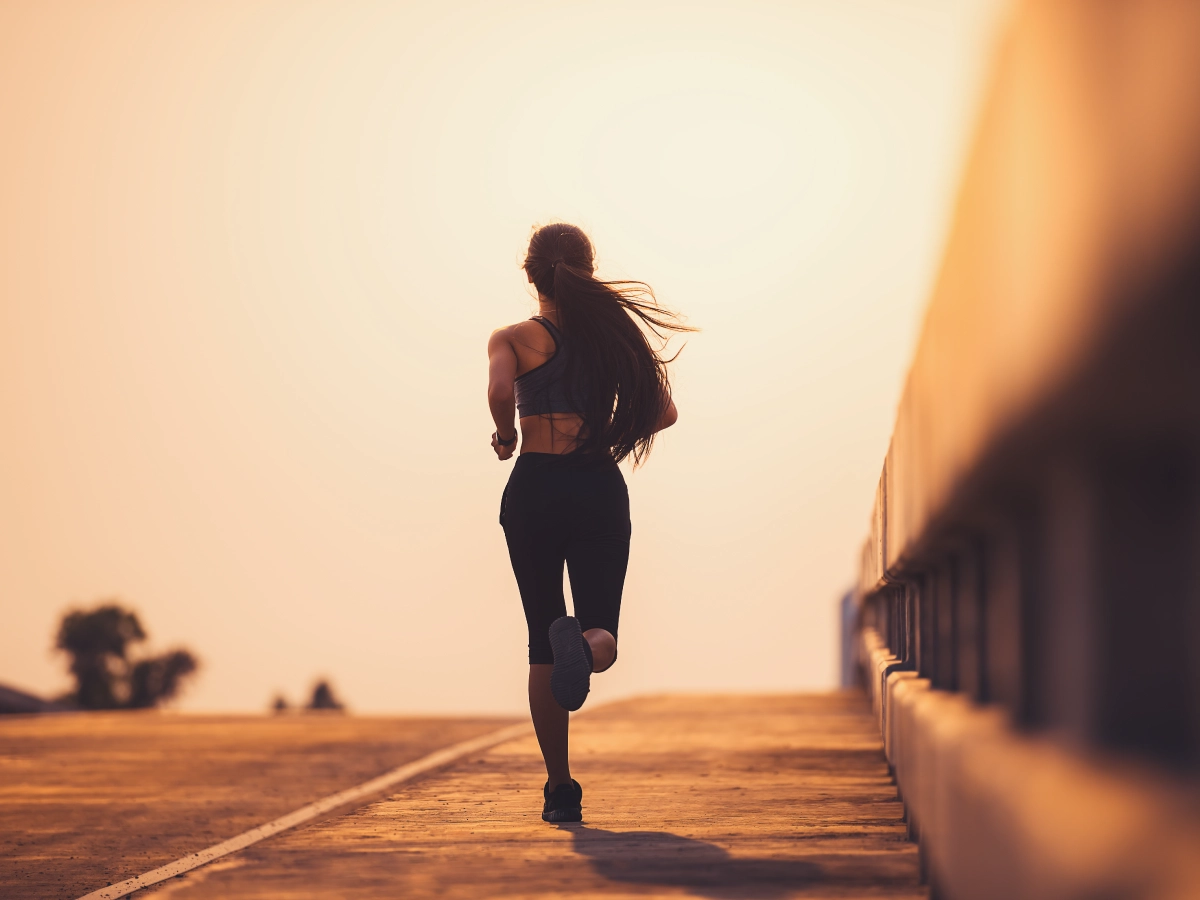 Woman jogging in the sunset, used in blog article about Nike and its brand message.