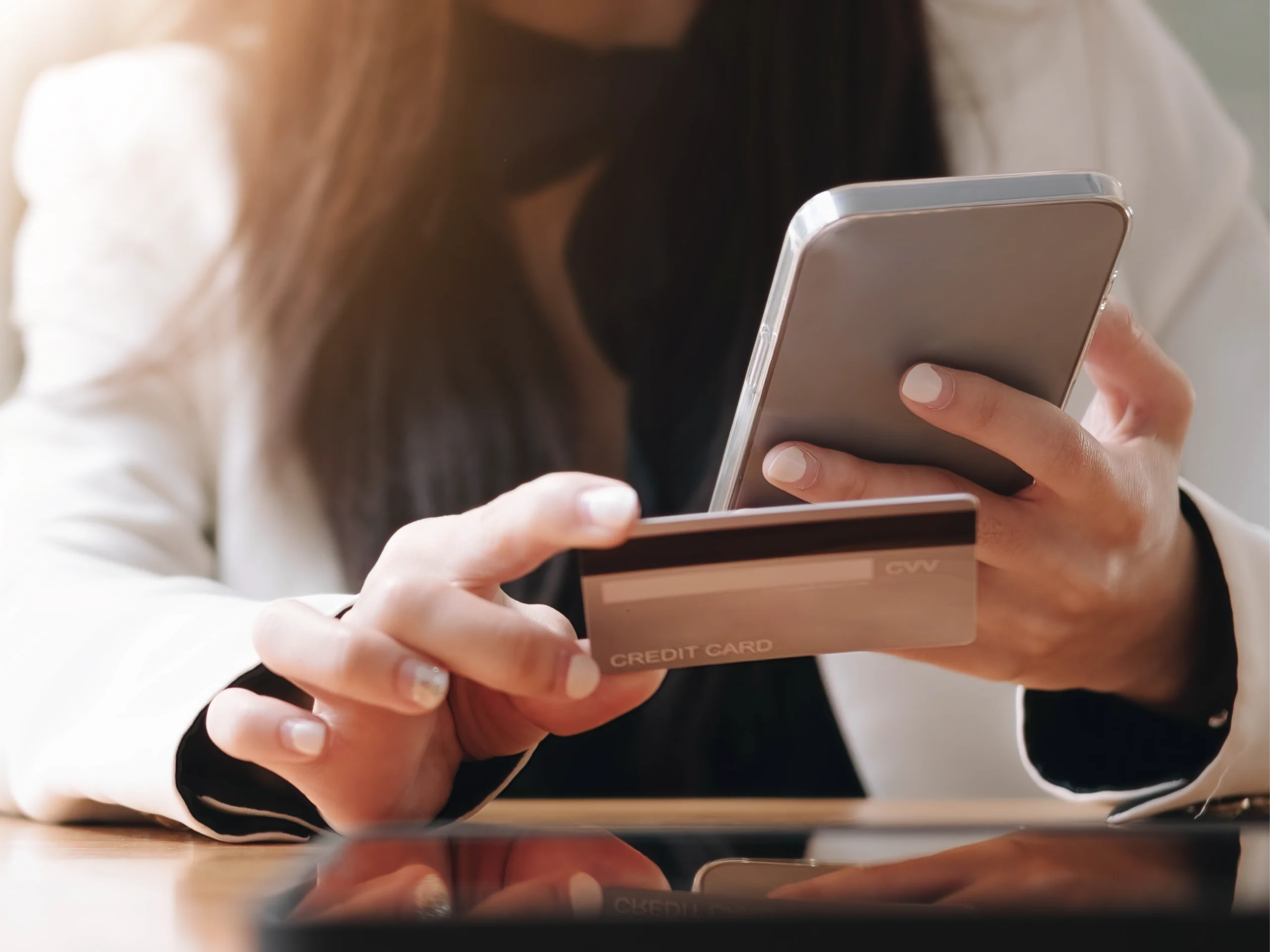 Woman's hands using a smartphone to scan a credit card for a digital transaction, featured in article about brand purpose in banking