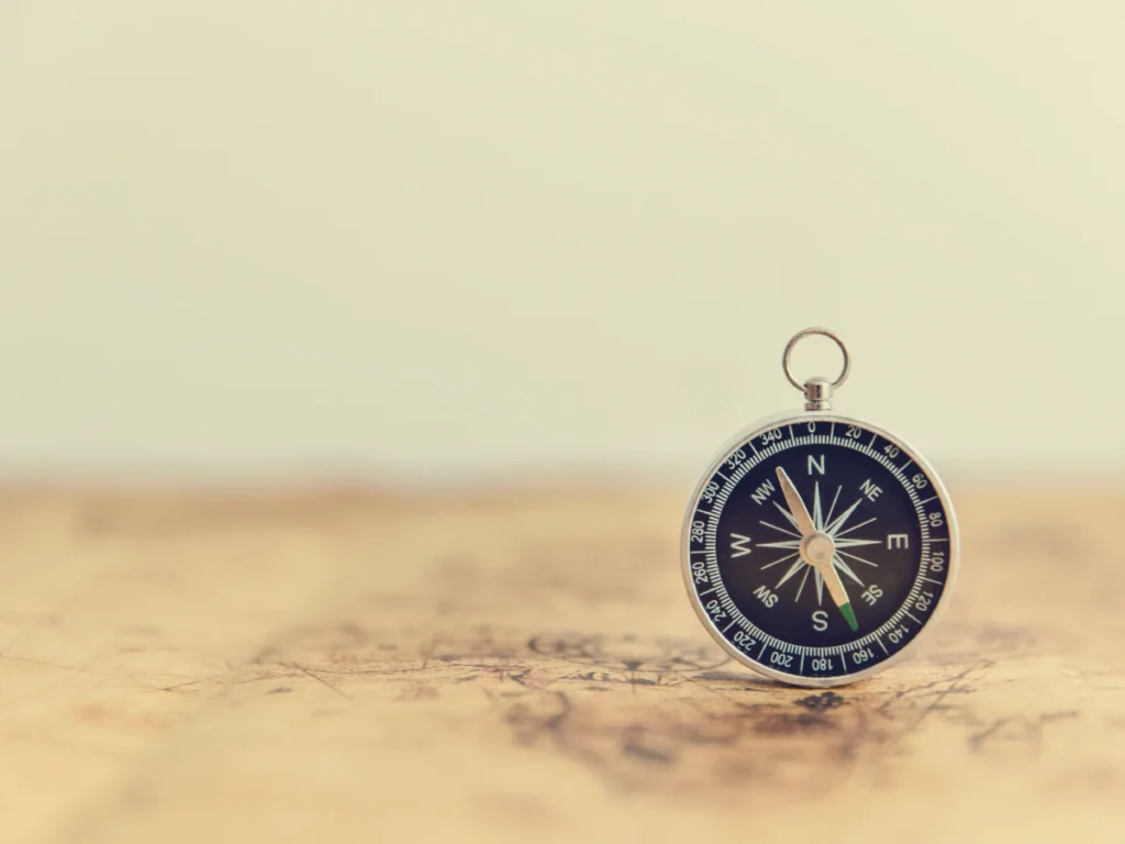 Analog compass on a map symbolising business strategy and finding true north.