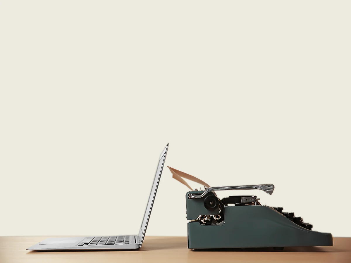 Laptop and typewriter facing each other, representing how a strong brand strategy evolves with the times to stay relevant.