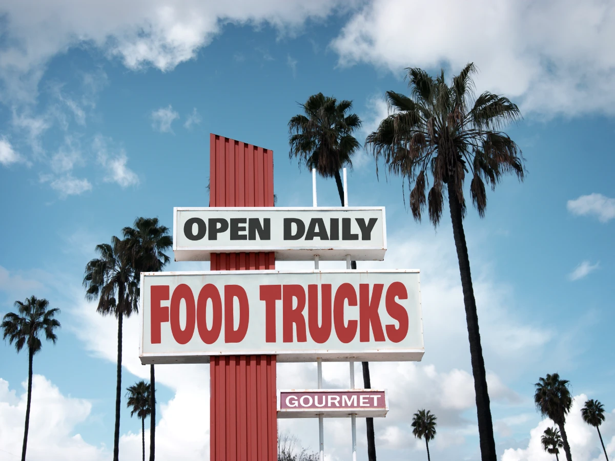 Large directional sign pointing towards food trucks, used for an article about brand experience.